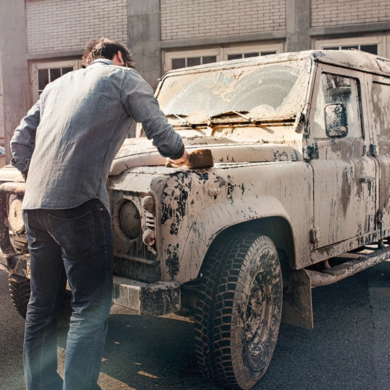 Un homme nettoie une voiture sale