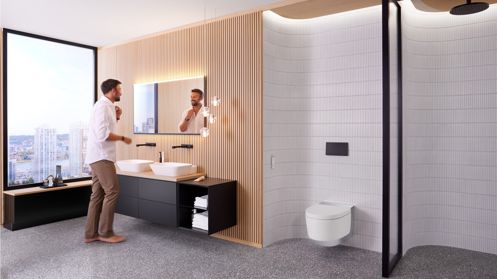 Man in bathroom standing in front of Geberit Option Plus Square mirror and black Geberit ONE bathroom furniture (© Geberit) Man in bathroom standing in front of Geberit Option Plus Square mirror and black Geberit ONE bathroom furniture (© Geberit)
