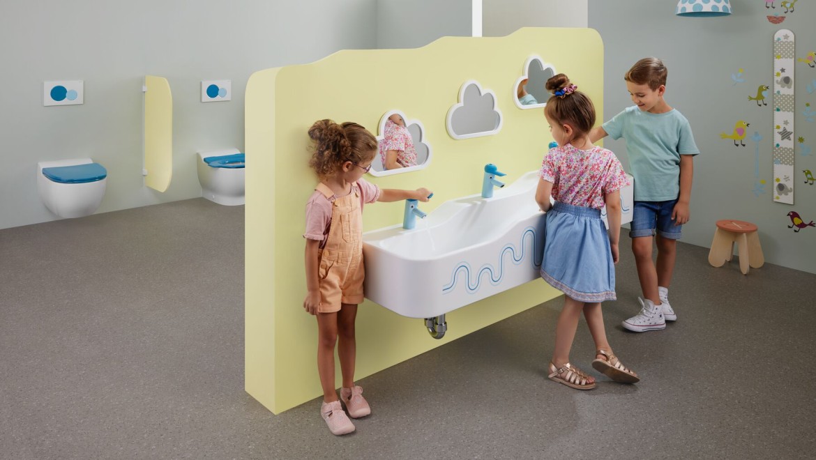 Children play in a sanitary room featuring Geberit Bambini