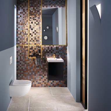 Salle de bains d’invités moderne dotée d’un WC et d’un lavabo Acanto placé devant un panneau en mosaïque.
