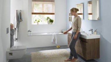 Woman stows products in the mirror cabinet