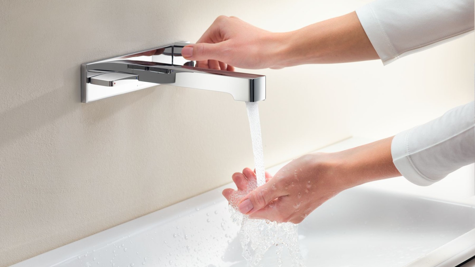 Macro image with hands turning a Geberit ONE tap and checking the water flow and temperature Macro image with hands turning a Geberit ONE tap and checking the water flow and temperature