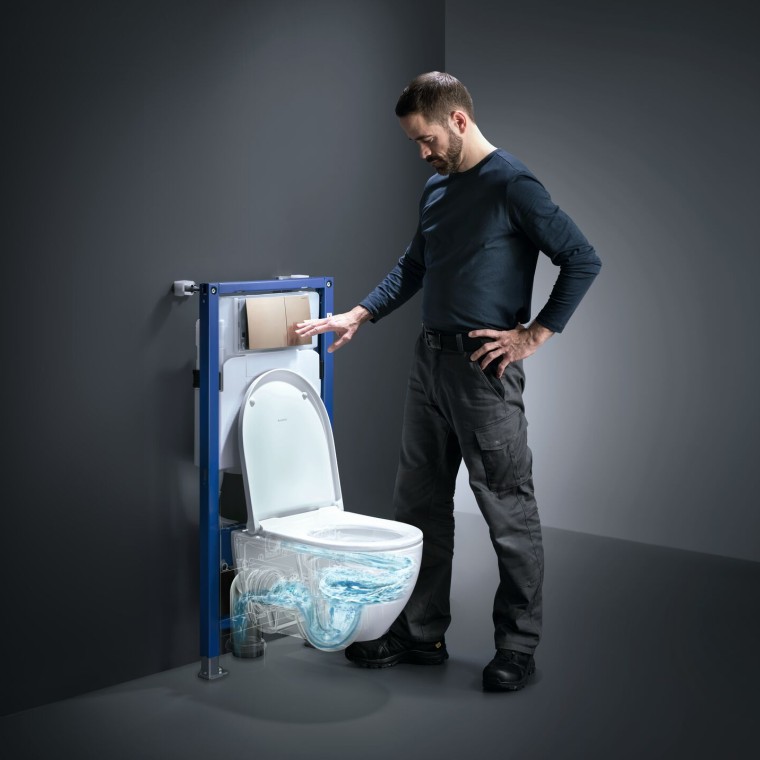 Un homme actionne la technologie de rinçage TurboFlush d'un WC Geberit Acanto Un homme actionne la technologie de rinçage TurboFlush d'un WC Geberit Acanto