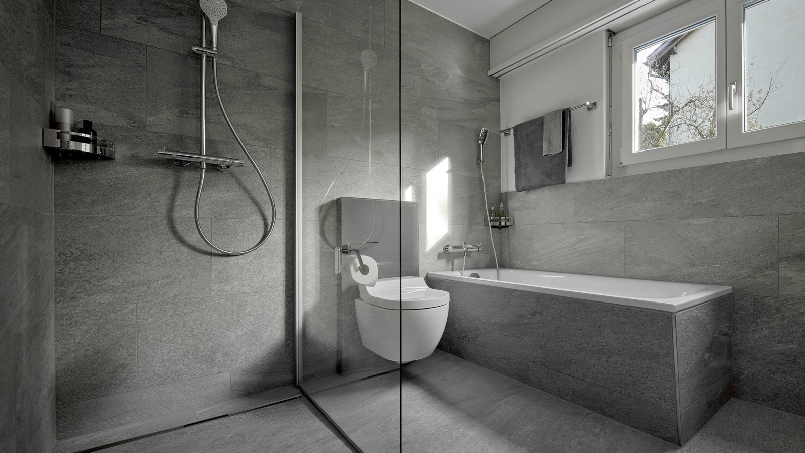 Un WC lavant entre une douche de plain-pied et une baignoire