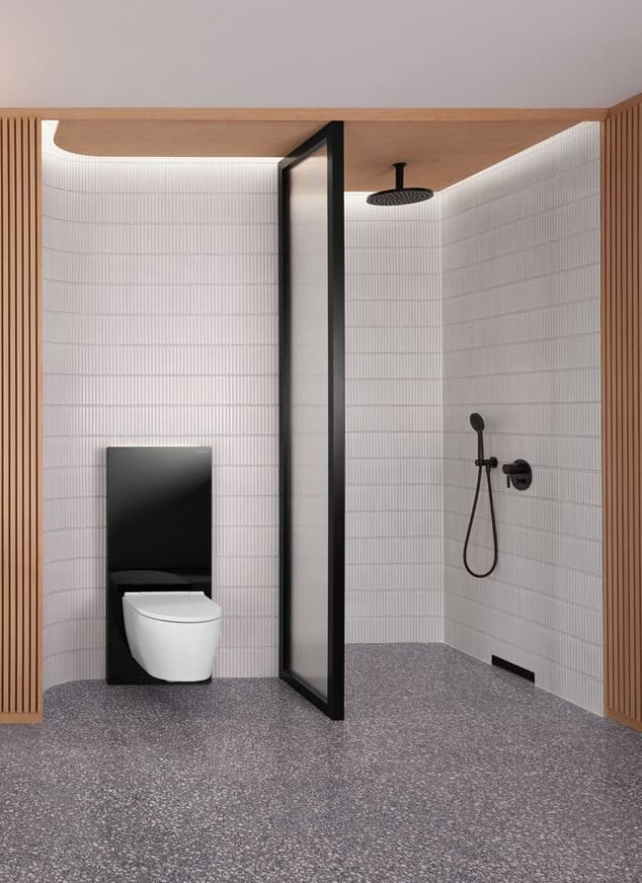Une salle de bains avec un mur en bois dotée d’un espace douche et WC en noir et blanc Une salle de bains avec un mur en bois dotée d’un espace douche et WC en noir et blanc