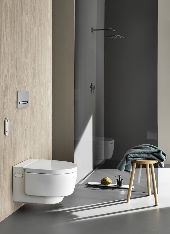 WC lavant Geberit AquaClean Mera Comfort avec télécommande et plaque de déclenchement Sigma50 (© Geberit) WC lavant Geberit AquaClean Mera Comfort avec télécommande et plaque de déclenchement Sigma50 (© Geberit)